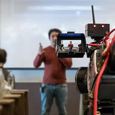 Budget AV camera and recording setup capturing a speaker in a classroom environment, used for Atlanta events or educational seminars